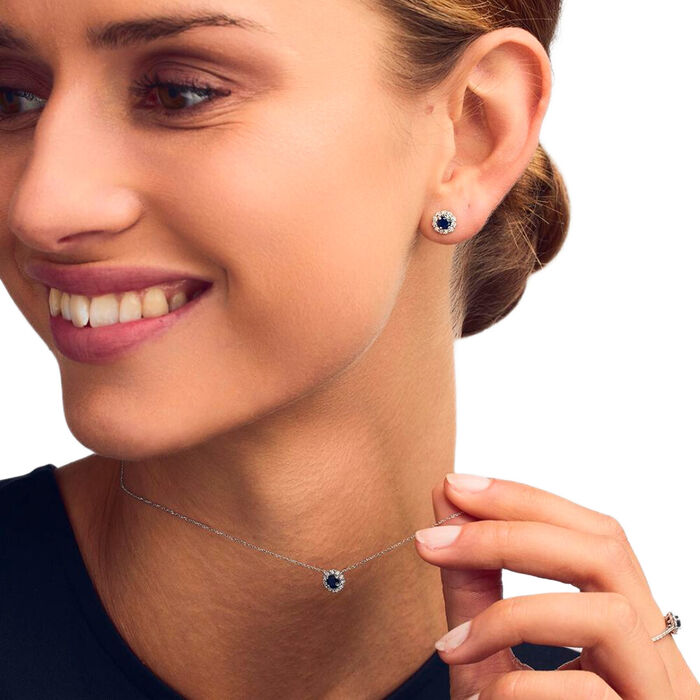 Modelo feminina com brinco e colar LECARRÉ em ouro branco com safira azul e diamantes ao redor.