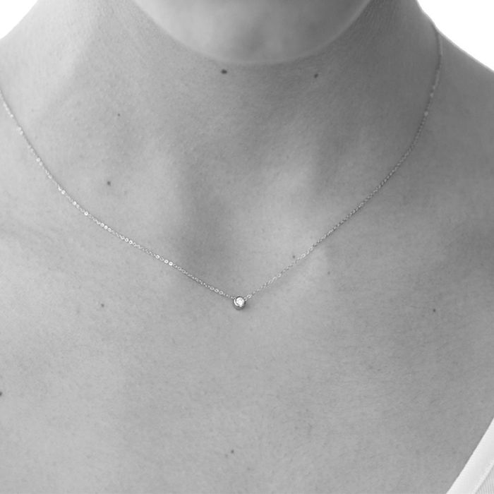 Modelo feminina com colar feminino Lecarré em ouro de 18k malha fina, com diamante redondo pendente.