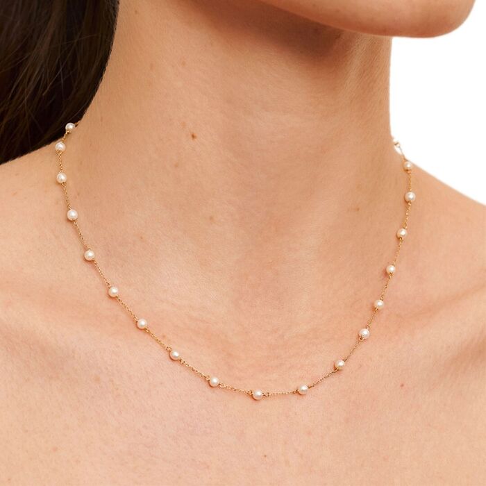 Modelo feminina com colar Lecarré em ouro amarelo de dezoito quilates com pérolas ao longo da malha.