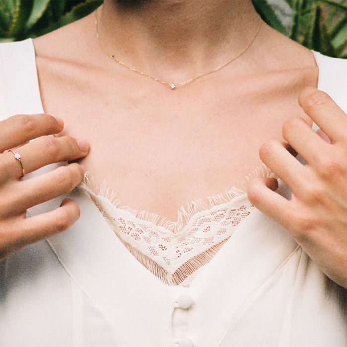 Modelo feminina com colar Lecarré em ouro amarelo com pendente forma de flor, cravado de diamantes.