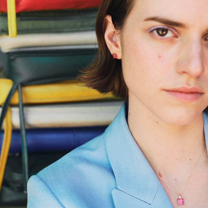 Modelo feminino a usar colar ouro amarelo com quartzo rosa pendente e apontamento de topázio branco.