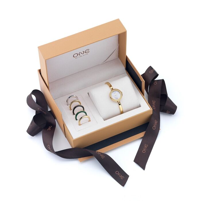 Box One com um relógio feminino dourado com zircónias e com cinco biseis diferentes ao lado.
