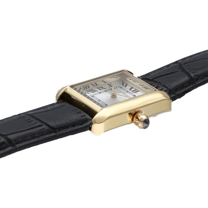 Detalhe do relógio Radiant de bracelete em pele preta e caixa retangular dourada.