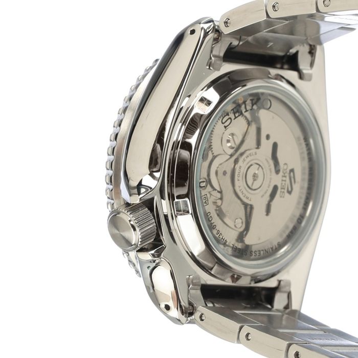 Vista traseira de relógio masculino Seiko 5, bracelete e caixa em aço prateada, tampa transparente.
