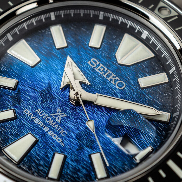 Detalhe de mostrador de relógio masculino Seiko Prospex, fundo azul a representar o mar.