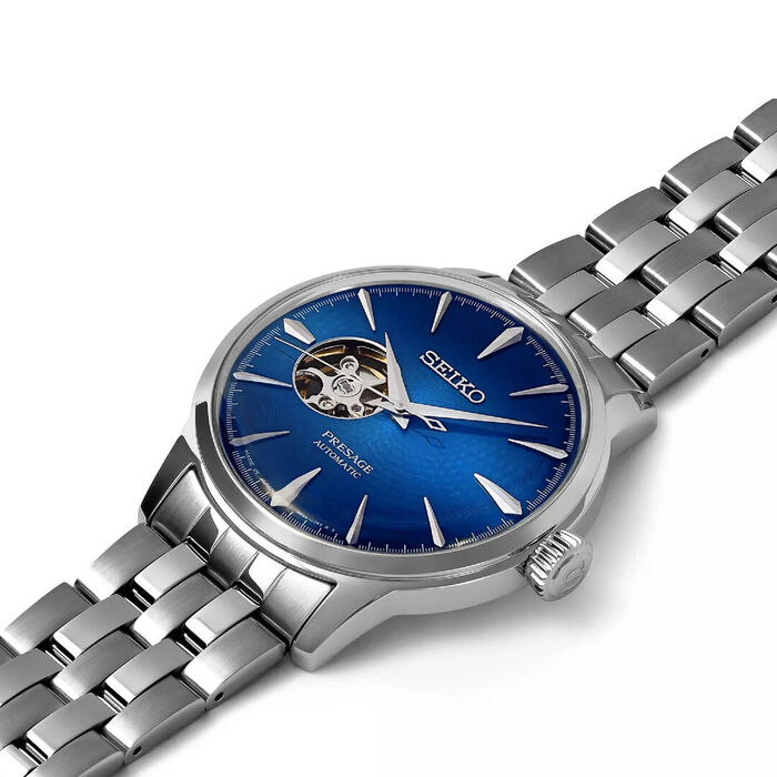 Vista detalhada de relógio masculino Seiko Presage, com caixa e bracelete prateada, mostrador azul.