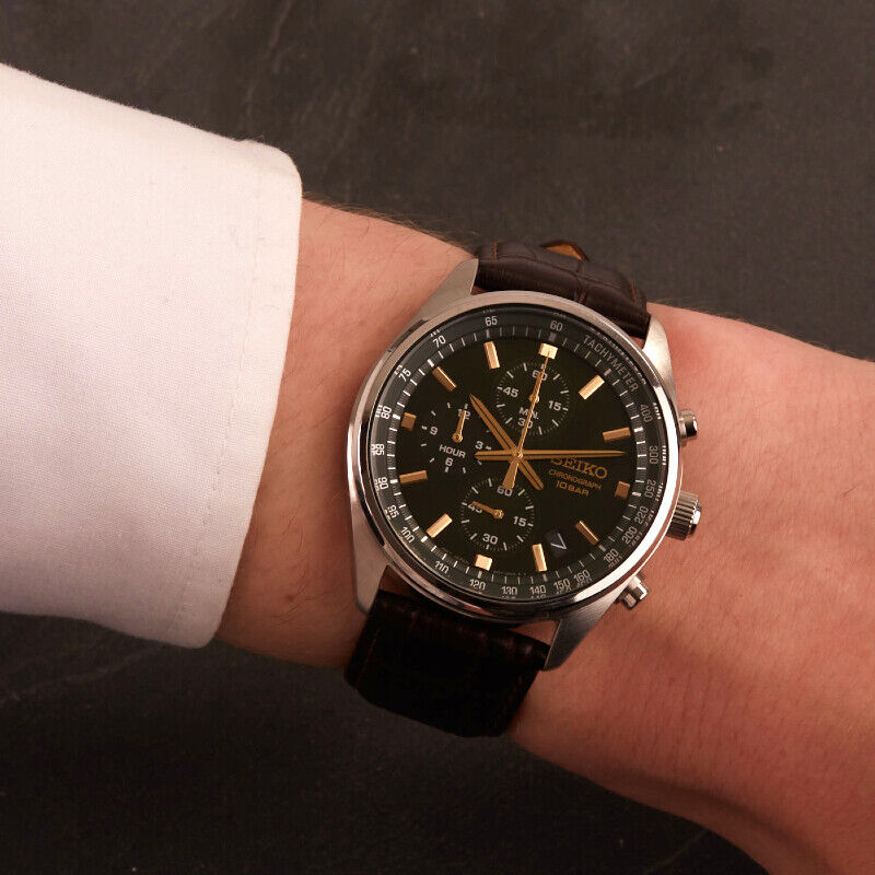 Pulso masculino com relógio Seiko Neo Sport, com bracelete em pele e caixa em aço, mostrador verde.