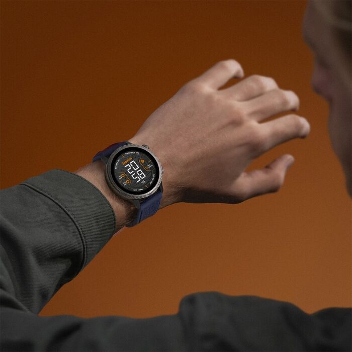 Modelo masculino com um Smartwatch Timberland de bracelete em pele azul sobre um fundo castanho.