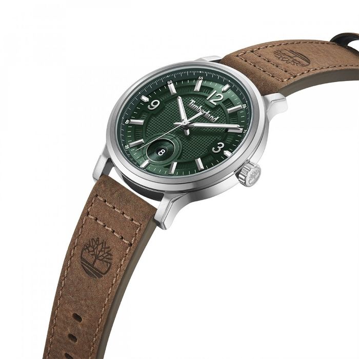 Detalhe de um relógio Timberland de bracelete em pele castanha e um mostrador verde com calendário.