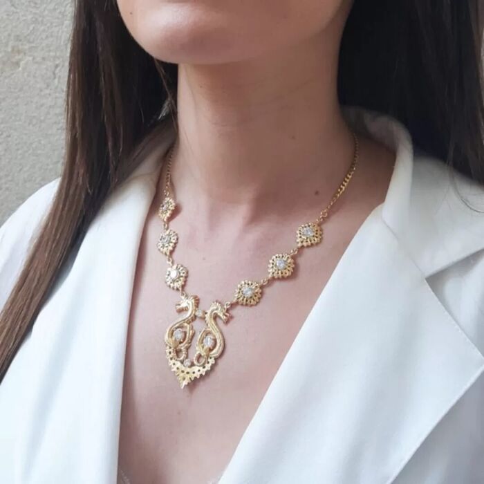 Modelo feminino com um colar dourado Portugal Jewels em estilo filigrana e com dois dragões.