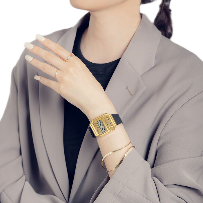 Senhora com relógio Casio digital com caixa retangular de cor dourada e bracelete de silicone preta
