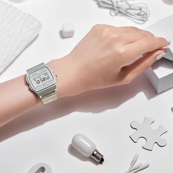 Relógop Casio digital com caixa e bracelete tranparenten mão da modelo.