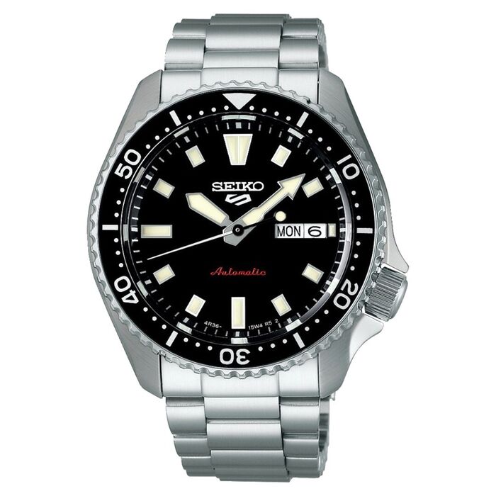 Relógio automático Seiko prateado de bisel e mostrador analógico preto com calendário nas 3 horas.
