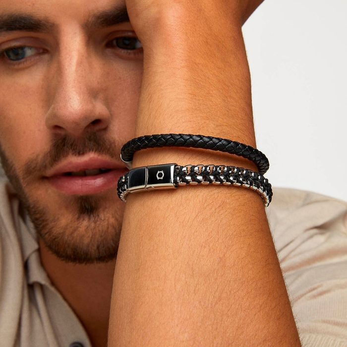 Homem com camisa com pulseiras one, uma em couro preto e outra em aço prateada