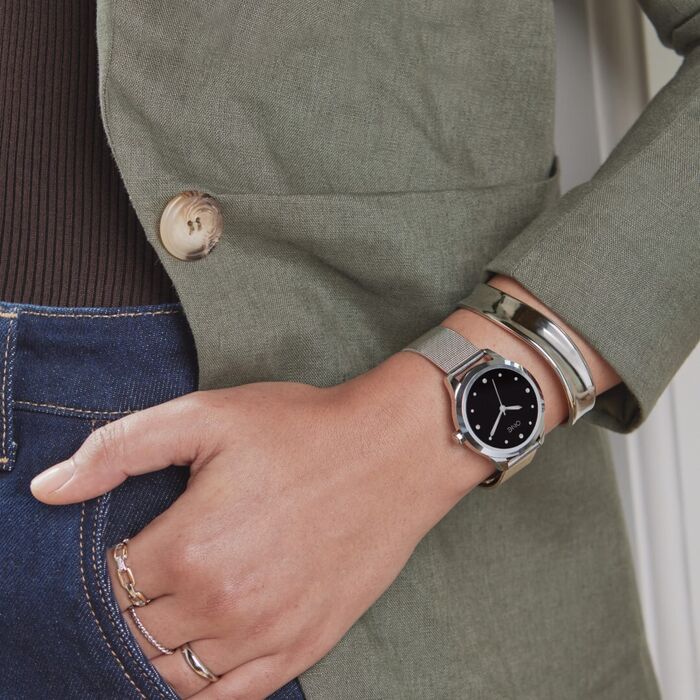 Senhora de camisa verde com smartwatch One com caixa prateada e bracelete milanesa da mesma cor
