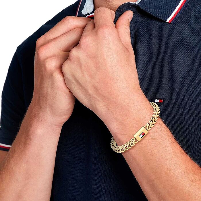 Pulseira Tommy Hilfiger para homem em aço dourado no pulso do modelo.