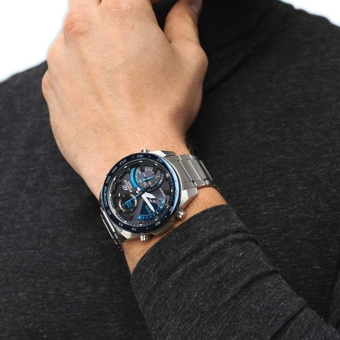 Relógio Casio Edifice com bracelet em aço e mostrador azul com multifunções, no pulso.