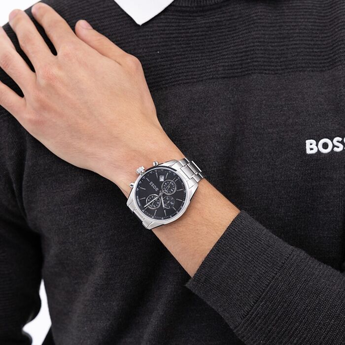 Relógio Boss com bracelete em aço prateada e mostrador preto com função de cronógrafo no pulso.