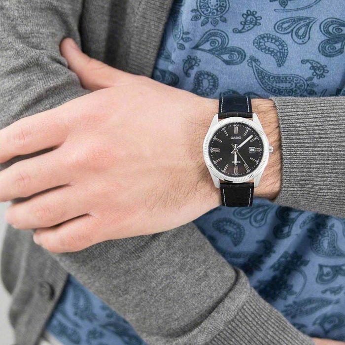 Homem com relógio analógico Casio de bracelete pele preta e caixa prateada, mostrador redondo preto