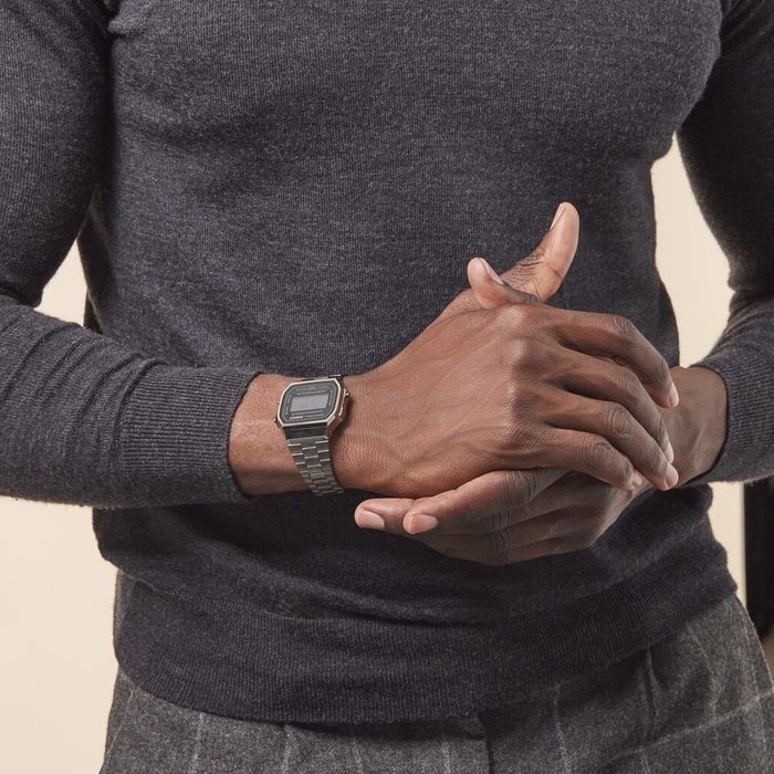 Homem com relógio Casio digital com caixa e bracelete em cinza escuro e mostrador preto quadrado
