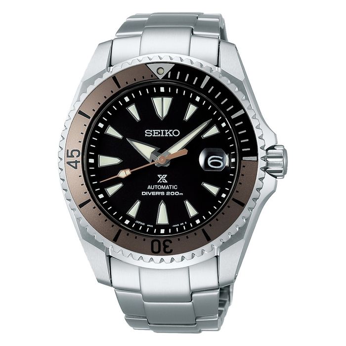 Relógio Seiko de bracelete e caixa prateadas, bisel castanho e um mostrador preto com calendário.