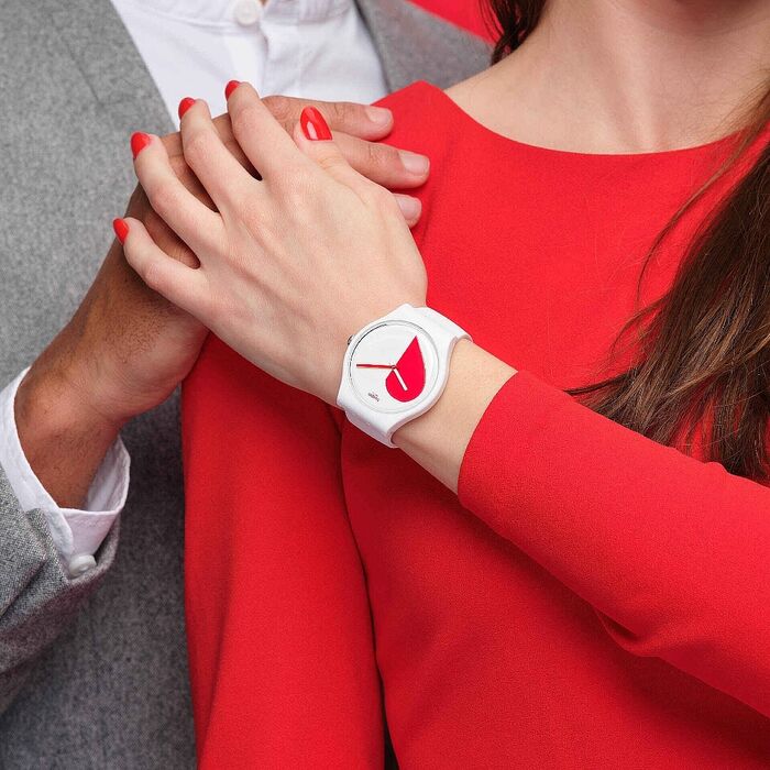 Duas senhoras com mãos entrelaçadas e em um pulso um relógio branco com coração vermelho e branco