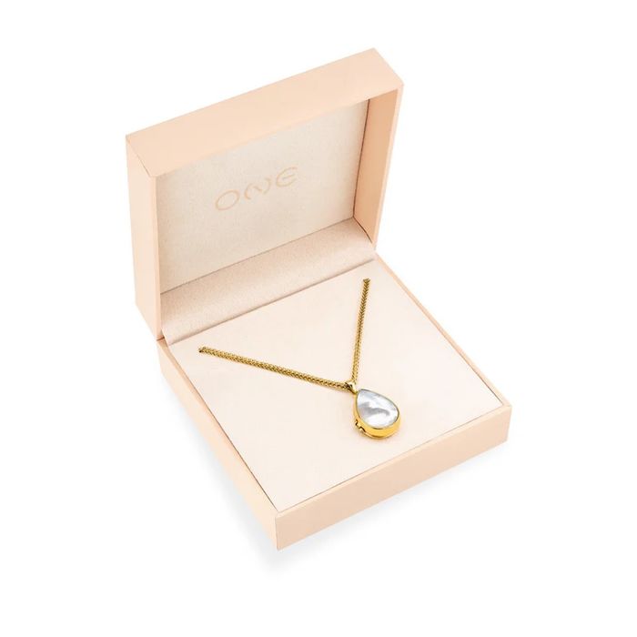 Caixa rosa com um colar One em aço dourado e um pendente relicário com madrepérola em forma de gota.