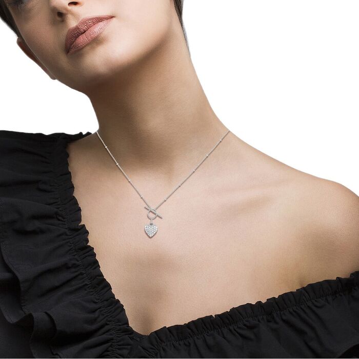 Modelo com colar prateado Unike feminino com fecho em T e um pendente de um coração com zircónias.