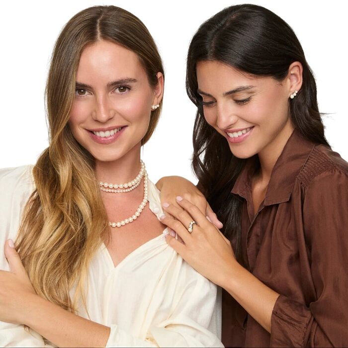 Duas modelos femininos com colares e brincos dourados com pérolas brancas de cultivo da Majorica.