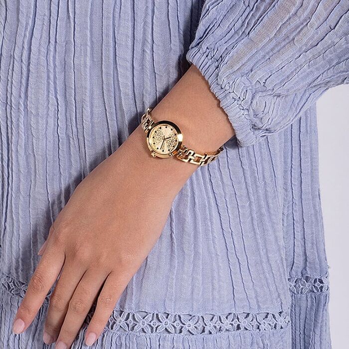 Pulso feminino com relógio dourado de mostrador redondo e bracelete de elos, vestido azul claro