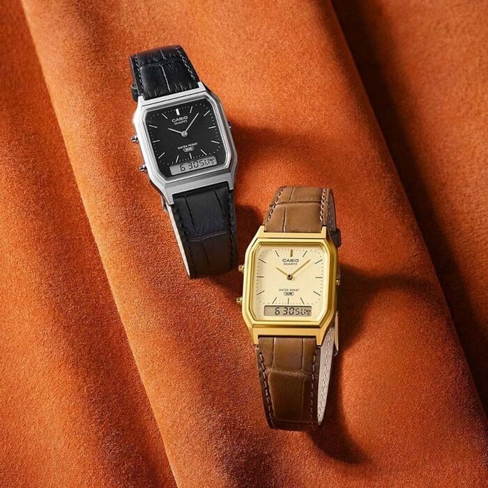 Dois relógios vintage: prateado com mostrador preto e bracelete preta; dourado com mostrador claro e