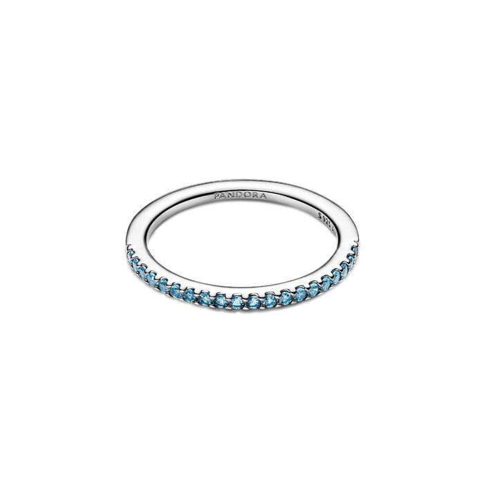 Anel feminino prateado Pandora, pousado, com zircónias azuis cravadas em metade do aro.