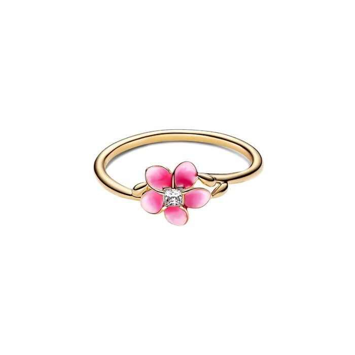 Anel dourado Pandora, pousado, com uma flor de pétalas em esmalte rosa e com uma zircónia no centro.