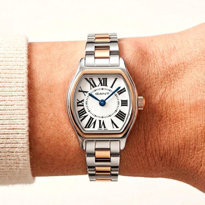 Relógio feminino da Gant com mostrador branco com os números em romano no pulso da modelo.