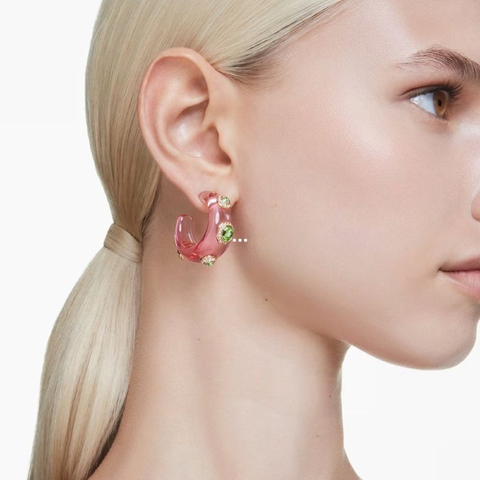 Brincos femininos coe de rosa redondos com cristais swarovski verdes e dourados, na modelo.