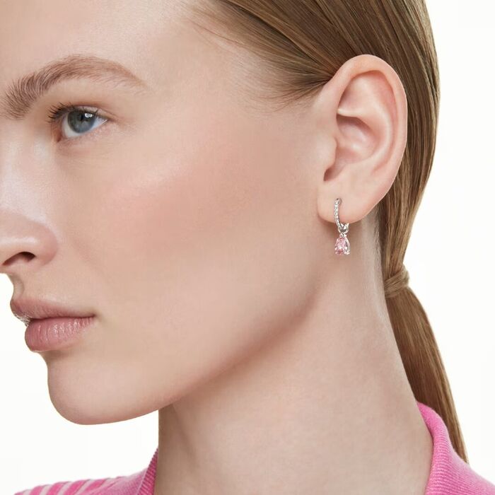 Brincos femininos compridos com cristais swarovski com pendente cor de rosa, na modelo.