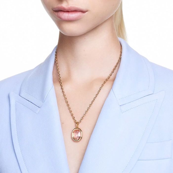 Colar Swarovski dourado com pedras cristal cor de rosa, no pescoço da modelo.