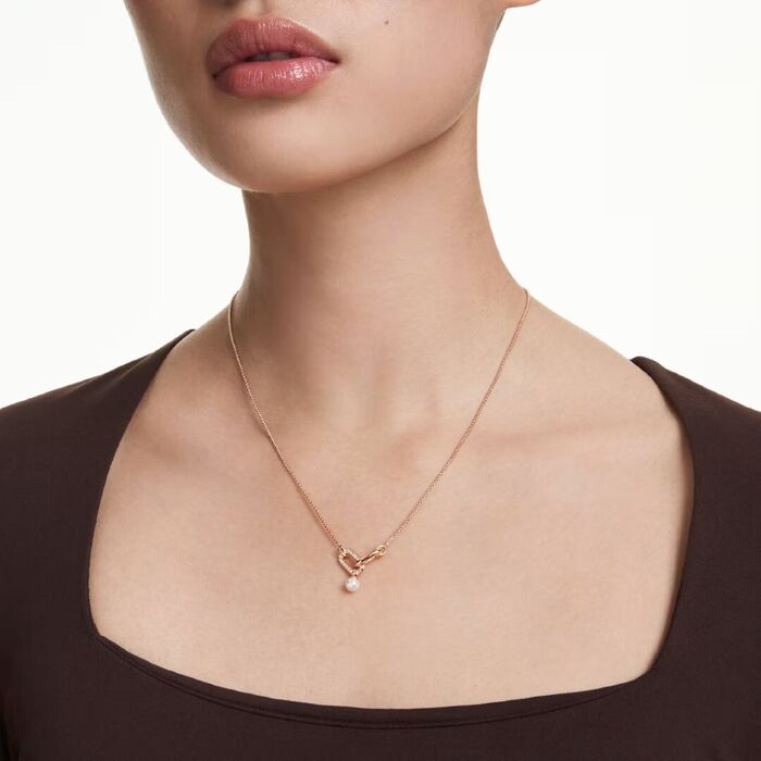 Colar Swarovski de cor rose gold com cristais swarovski e pérola, na modelo.