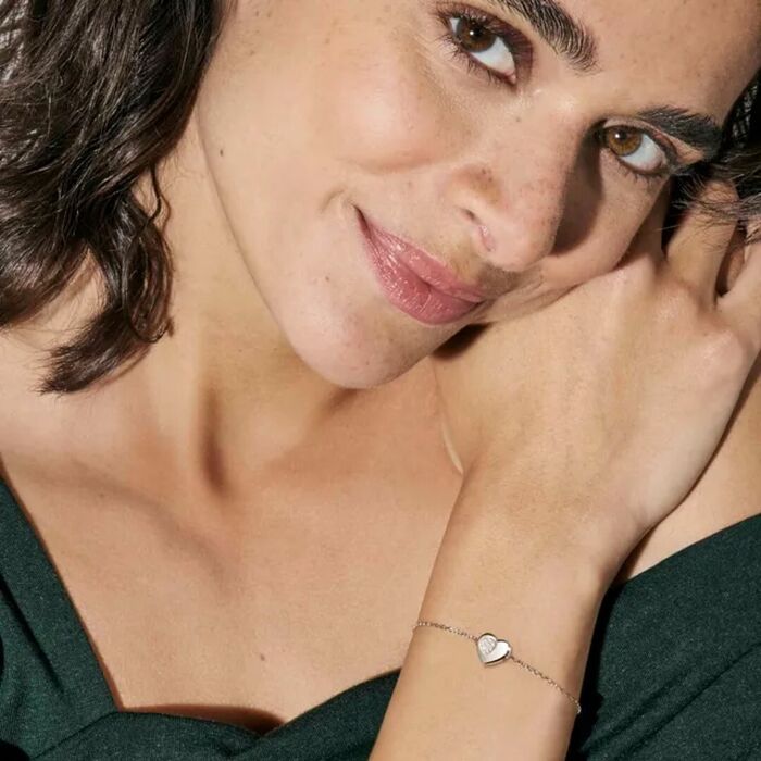 Modelo feminino com pulseira Nomination prateada com um coração com zircónias numa zona recortada.