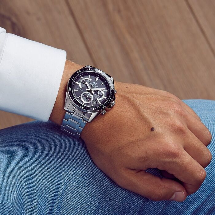 Relógio Casio Edifice com bracelete em aço e mostrador preto, com cronógrafo e calendário, no pulso.