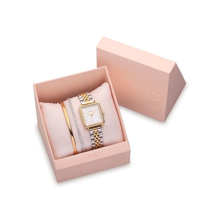 Caixa rosa aberta com um relógio analógico bicolor, uma pulseira e uma escrava dourada da One.