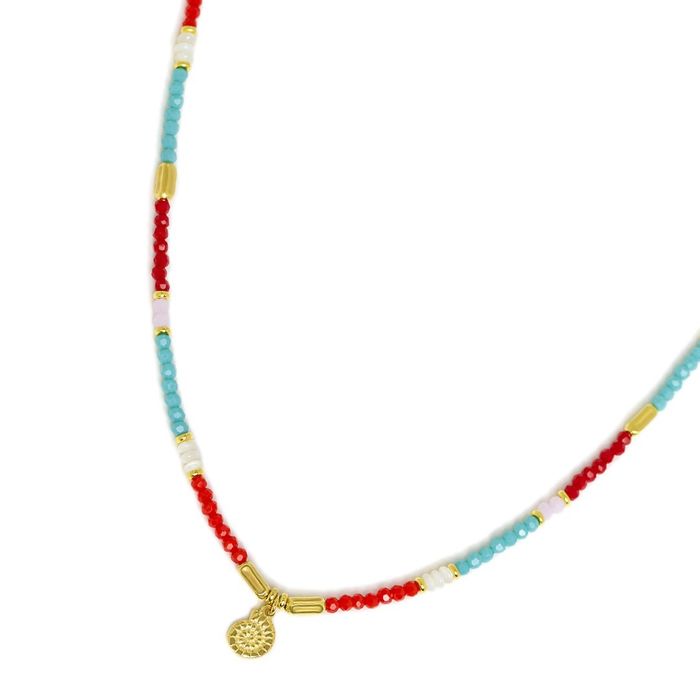Colar Eugénio Campos pousado com contas coloridas na malha e com um pendente dourado de uma amonite.