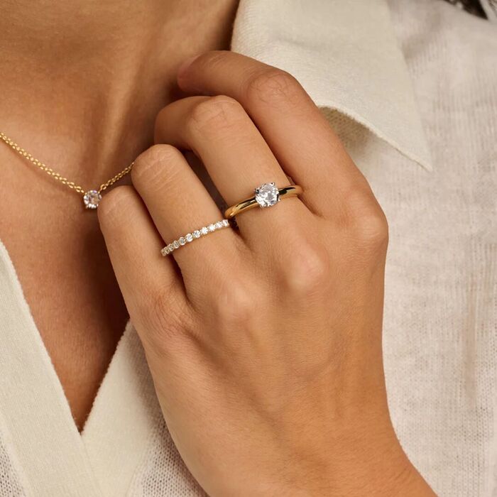 Anel TI SENTO Milano bicolor para mulher prateado e dourado com zircónia no meio, no dedo da modelo.
