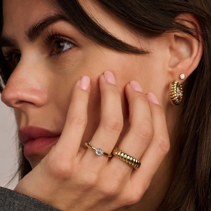 Anel TI SENTO Milano bicolor para mulher prateado e dourado com zircónia no meio, no dedo da modelo.