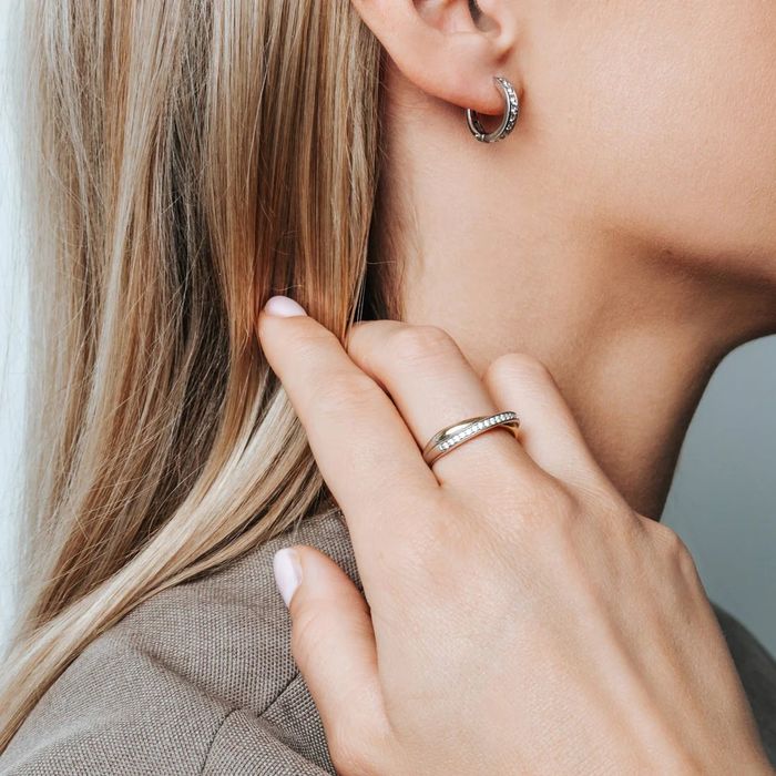 Um anel Ti Sento feminino bicolor com dourado e prateado com zircónias, no dedo.