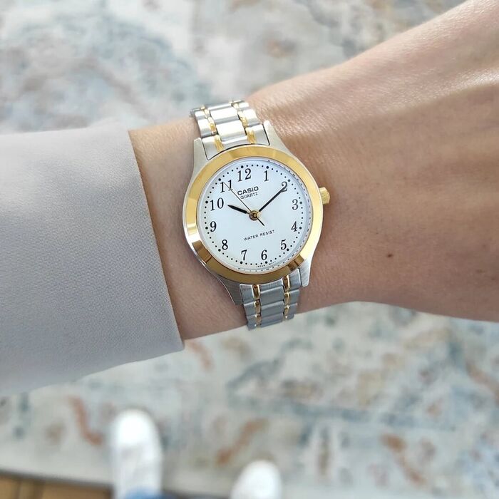 Relógio Casio mulher com bracelete bicolor em caço com números no mostrador no pulso.