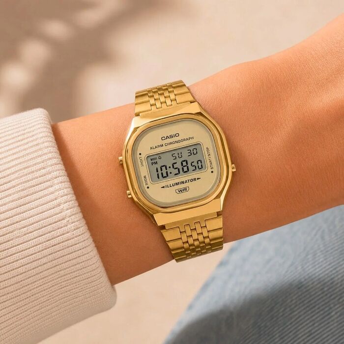 Relógio Casio com mostrador digital com bracelete e caixa dourados em aço inoxidável, no pulso.