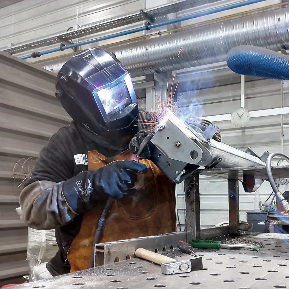 V Laser On welder performing manual welding on a steel component for industrial machinery in Portugal