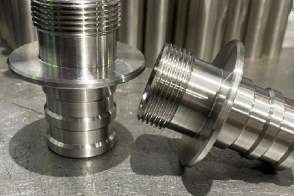 Two CNC turned steel parts on a table, manufactured by V Laser On in Portugal