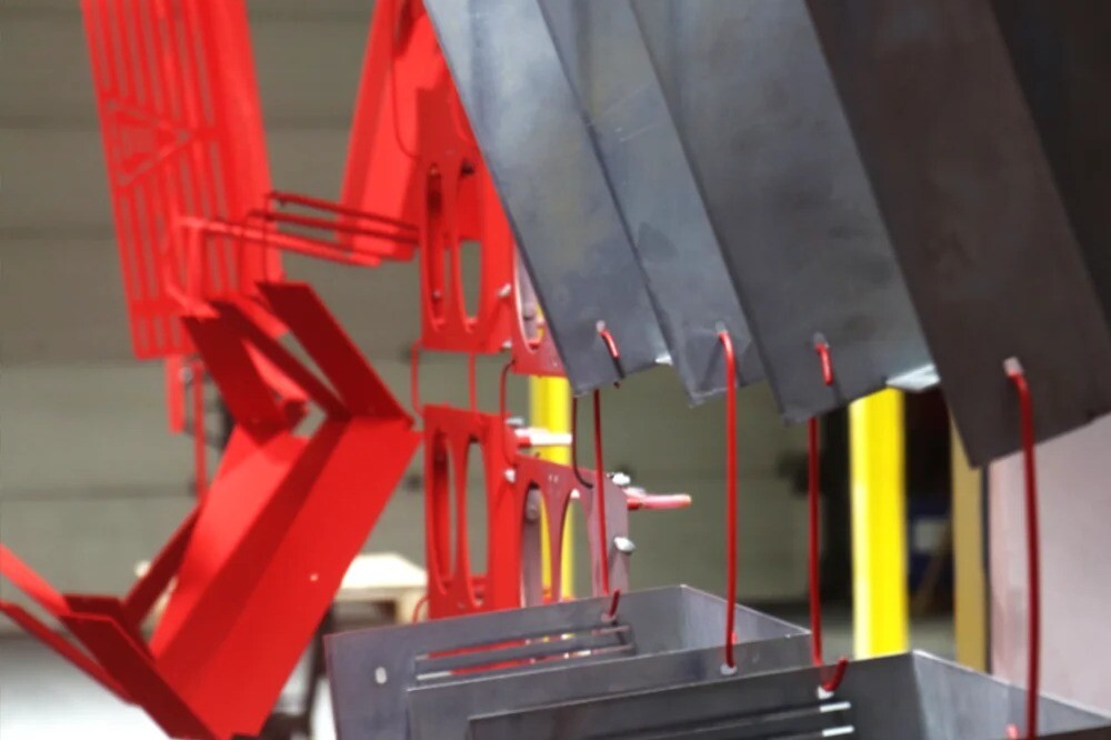 Electrostatic red epoxy powder coating line with unpainted and painted metal parts at V Laser On in Portugal